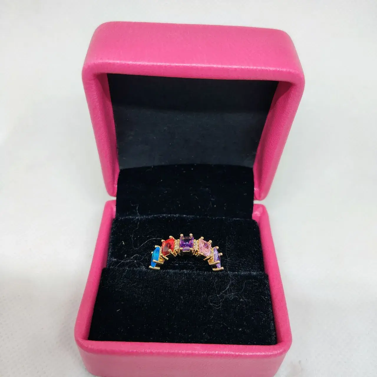 Picture of vibrant gold ring adorned with colorful gemstones,
